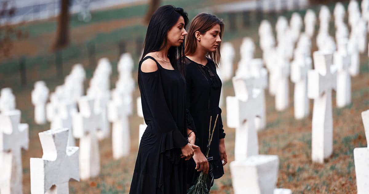 Sad women attending a cemetery