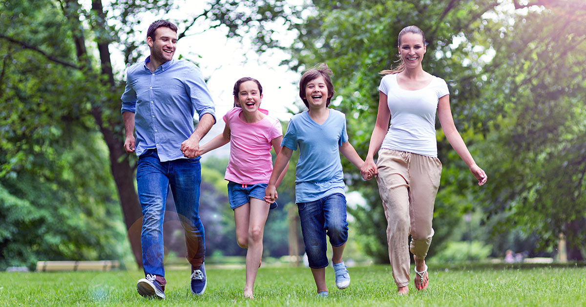 Happy family holding hands as they run in a row