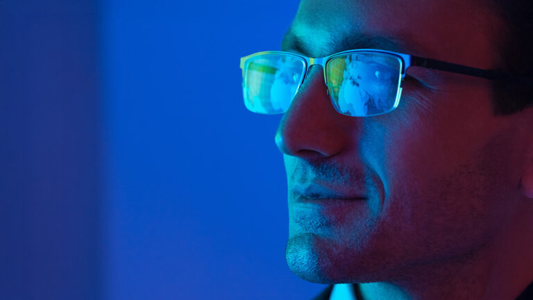 Business professional wearing glasses in blue light