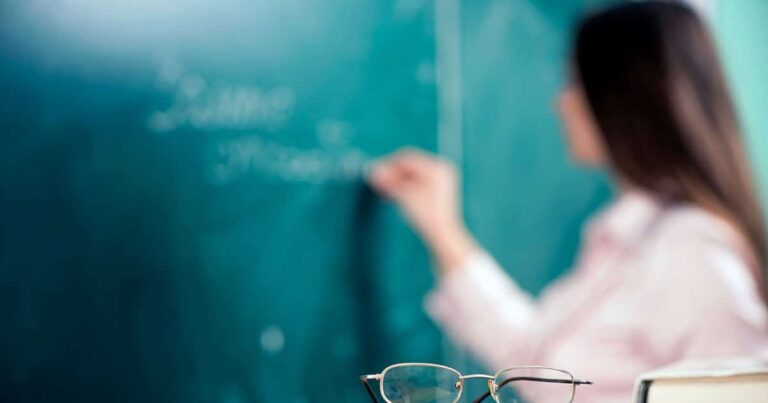 Classroom teacher writing on blackboard