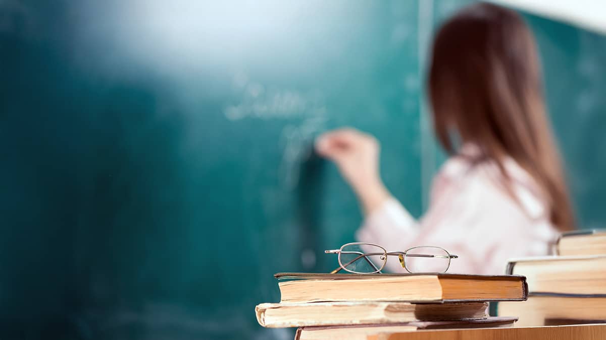 Classroom teacher writing on blackboard