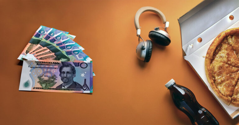 Consumer products and money on orange desk