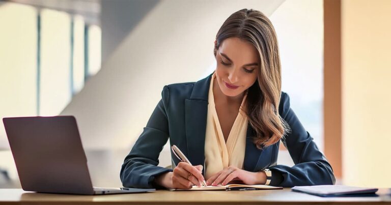 Professional woman at desk making notes