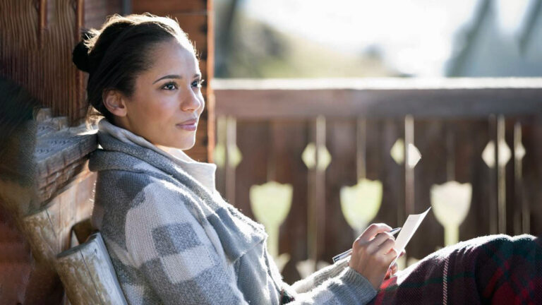 Woman making notes while looking out and up