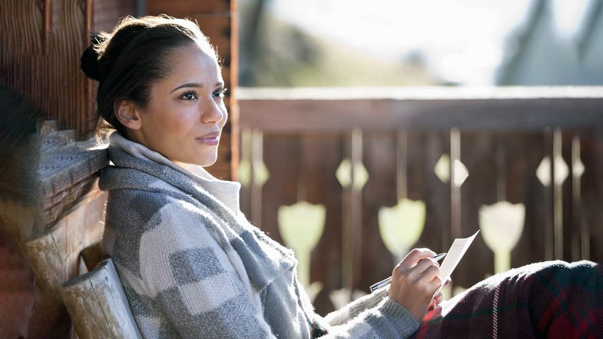 Woman making notes while looking out and up
