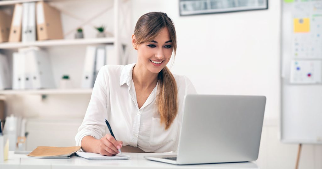 Woman taking notes from laptop