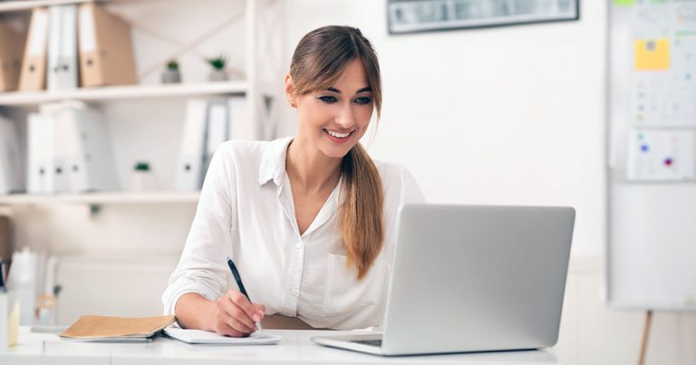 Woman taking notes from laptop